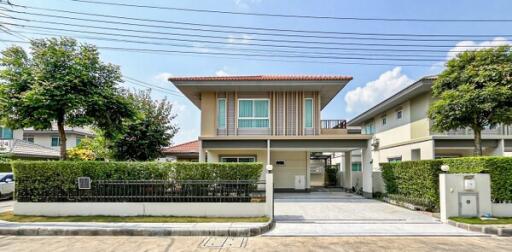 Suburban single-family house with fenced yard and clear blue sky