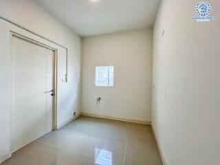 Empty bedroom with white walls and tiled flooring