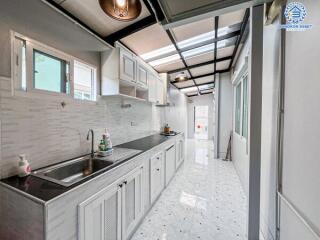 Modern kitchen with stainless steel sink and white cabinetry