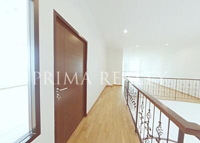 Bright hallway with wooden floors and intricate iron balustrade