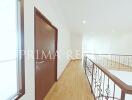 Bright hallway with wooden floors and intricate iron balustrade