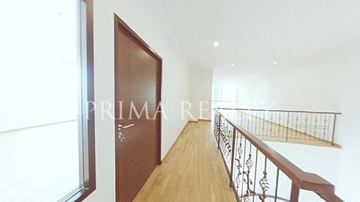 Bright hallway with wooden floors and intricate iron balustrade