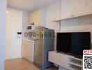 Compact studio apartment with modern kitchenette and entertainment area