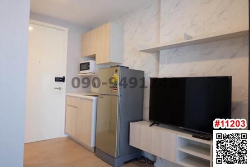 Compact studio apartment with modern kitchenette and entertainment area