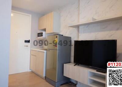 Compact studio apartment with modern kitchenette and entertainment area