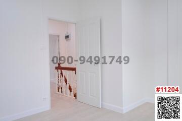 View of a white-walled corridor with doors leading to rooms inside a residential building