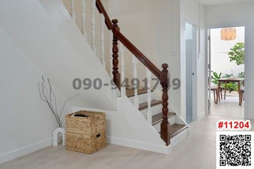 Bright entrance hall with wooden staircase and modern furnishings