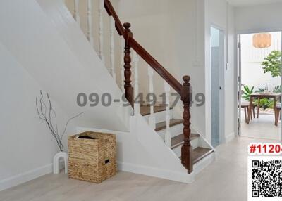 Bright entrance hall with wooden staircase and modern furnishings