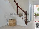 Bright entrance hall with wooden staircase and modern furnishings