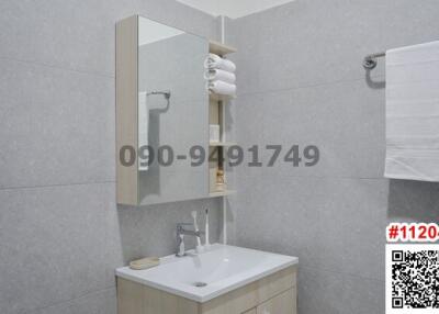 Modern bathroom interior with tile finishing and mounted sink cabinet