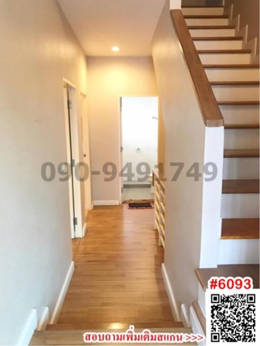 Bright hallway with wooden floors and staircase leading to upper level