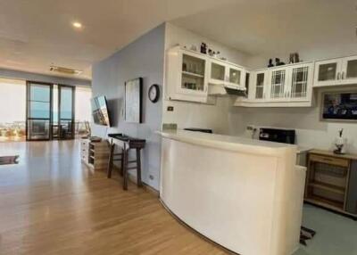 Modern kitchen with open plan design featuring a breakfast bar, ample cabinetry, and hardwood floors