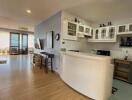 Modern kitchen with open plan design featuring a breakfast bar, ample cabinetry, and hardwood floors