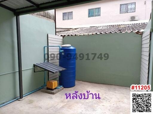 Partially covered outdoor area with storage tank and bench