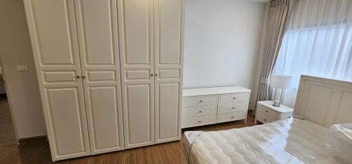 Spacious bedroom with large wardrobe and hardwood flooring