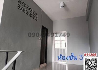 Gray painted hallway with decorative lattice wall vent and tiled flooring