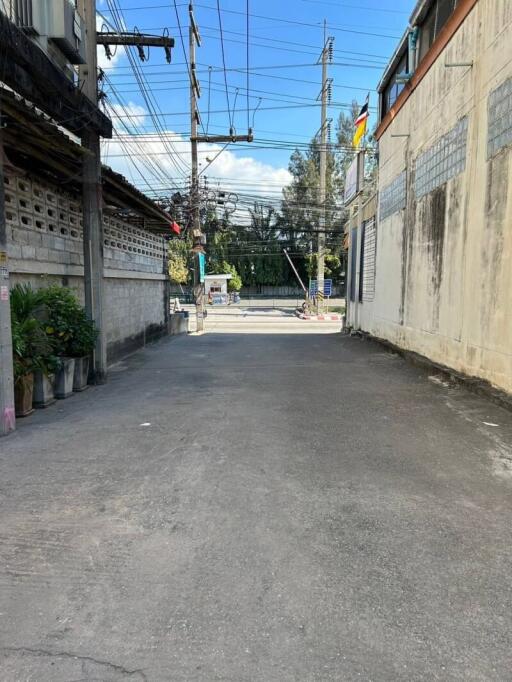 Street view outside the property showing the access road and surrounding walls