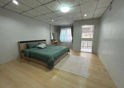 Spacious bedroom with queen-sized bed and hardwood floors