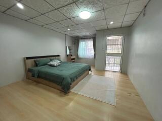 Spacious bedroom with queen-sized bed and hardwood floors