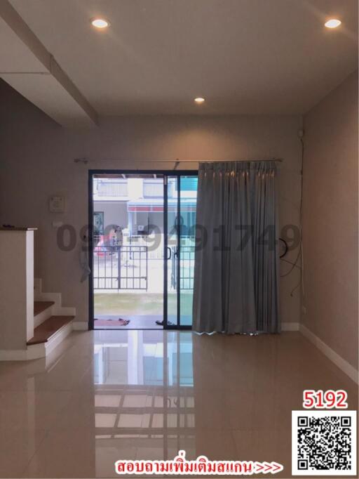 Spacious living room with tiled flooring and glass doors leading outside