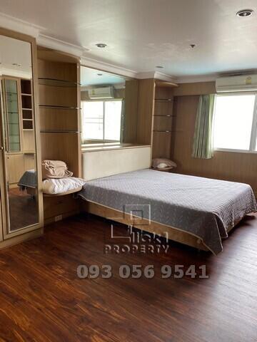 Spacious bedroom with wooden flooring and built-in closet