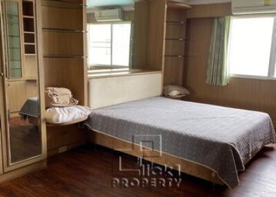 Spacious bedroom with wooden flooring and built-in closet