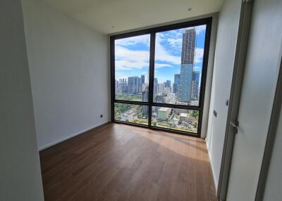 Empty bedroom with large window overlooking the city