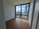 Empty bedroom with large window overlooking the city