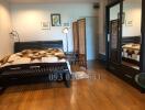 Spacious bedroom with wooden flooring and tasteful furnishings