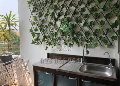Balcony with a green plant wall, sink and drying rack