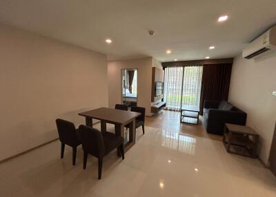 Spacious and well-lit living room with glossy tiled flooring, large windows and modern furnishings