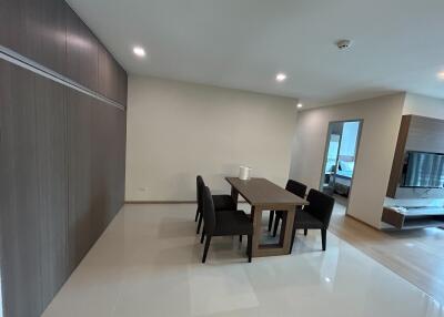 Modern dining area adjacent to the living room with a large wooden table and chairs