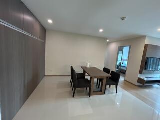 Modern dining area adjacent to the living room with a large wooden table and chairs