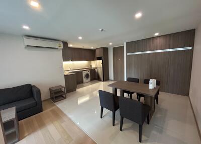 Spacious living room with combined kitchenette featuring modern appliances and furniture