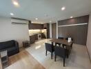 Spacious living room with combined kitchenette featuring modern appliances and furniture