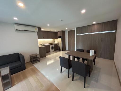 Spacious living room with combined kitchenette featuring modern appliances and furniture