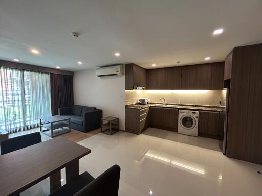 Modern open-plan living room and kitchen with washing machine