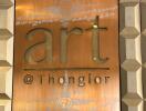 Artistic signboard with intricate design on a textured wall at Thonglor