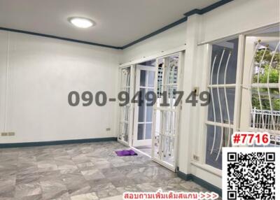 Spacious empty room with gray tiled flooring and large windows with security grills