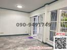Spacious empty room with gray tiled flooring and large windows with security grills