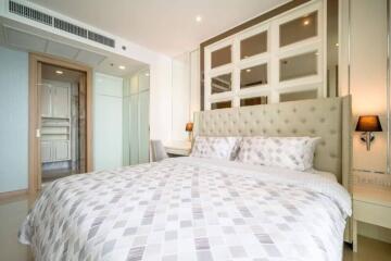 Spacious bedroom with contemporary design featuring a large bed with stylish bedding, built-in shelves and modern decor