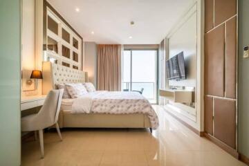 Modern bedroom interior with king-sized bed, ample lighting, and access to a balcony