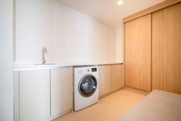 Compact laundry room with modern washing machine and built-in cabinetry