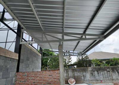 Unfinished outdoor area with metal roofing and brick walls