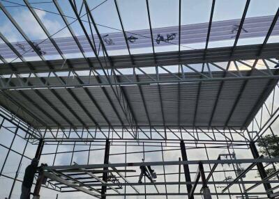 Under construction building with metal framework and partially installed roof