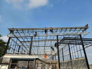 Workers constructing a building frame under a clear sky