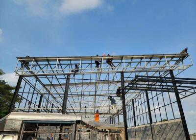 Workers constructing a building frame under a clear sky