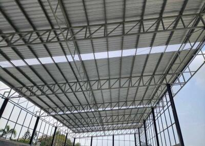 Spacious industrial building with metal framework and roof structure under construction