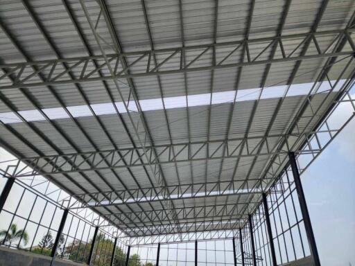Spacious industrial building with metal framework and roof structure under construction