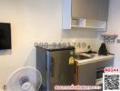 Compact modern kitchen with stainless steel refrigerator and electric stove